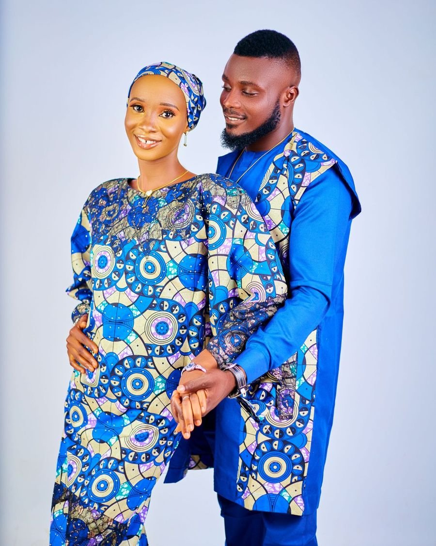 Un couple souriant en tenues traditionnelles bleues assorties